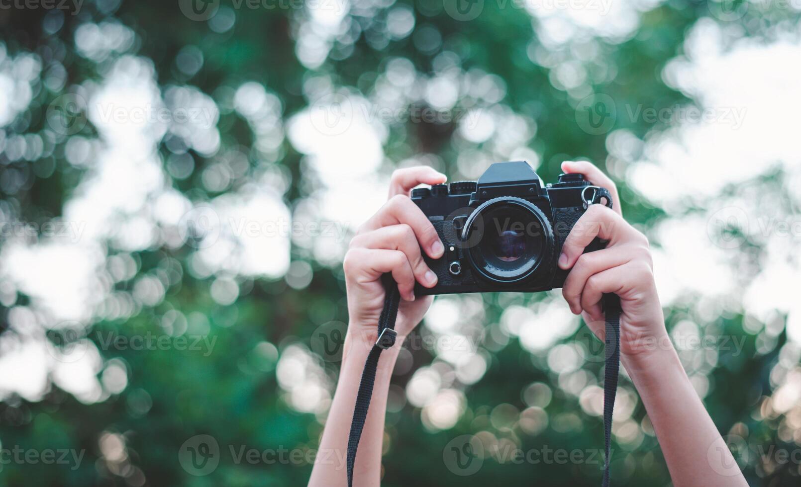 de hand- dat is Holding omhoog houdt de oud camera naar nemen een afbeelding. foto