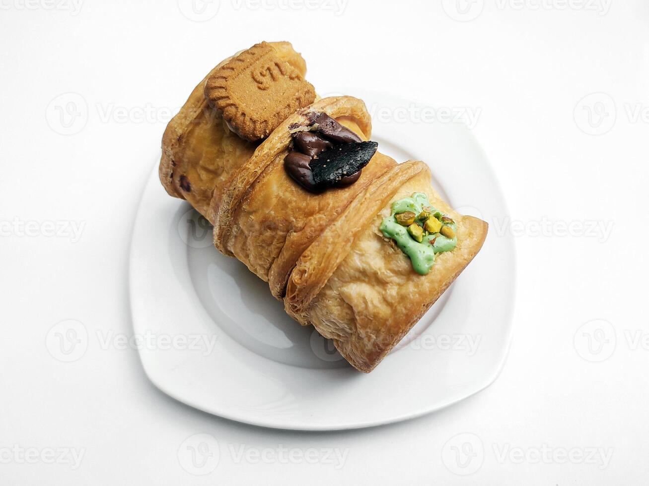 cromboloni, nieuw york rollen croissant met een verscheidenheid van saus toppings, geserveerd Aan een wit bord en geïsoleerd wit achtergrond. foto