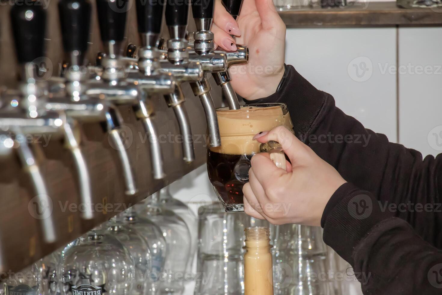 achter de balie. vrouwen handen prachtig en gemakkelijk gieten bier in een fles. foto