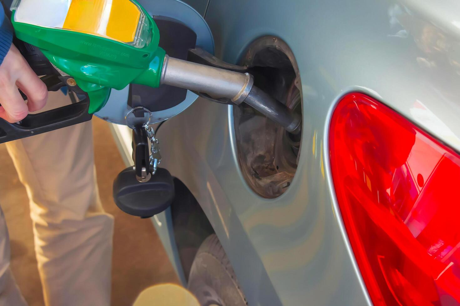 tanken de auto Bij een gas- station brandstof pomp. foto