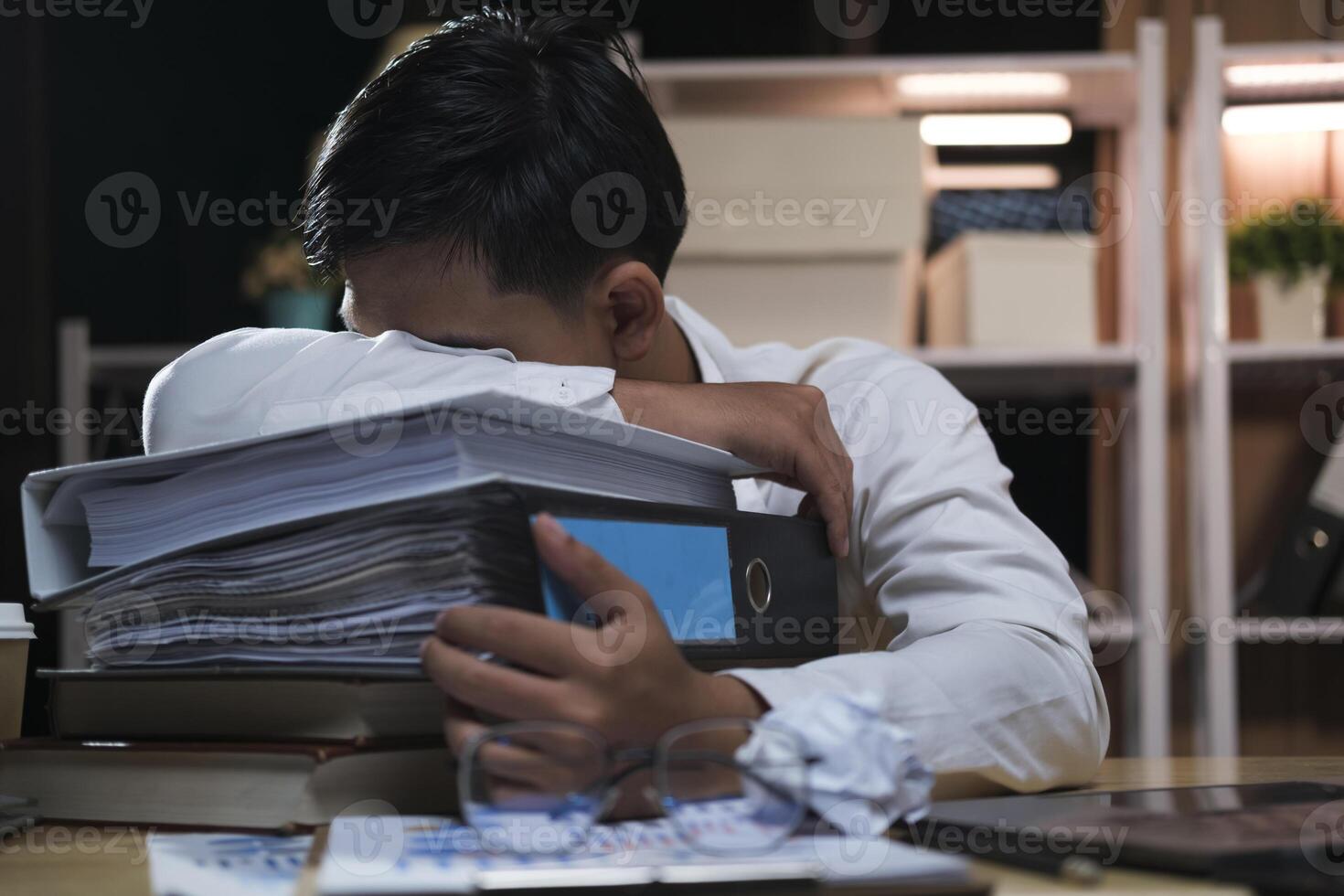 jong moe zakenman aan het liegen Aan tafel Bij nacht kantoor. foto