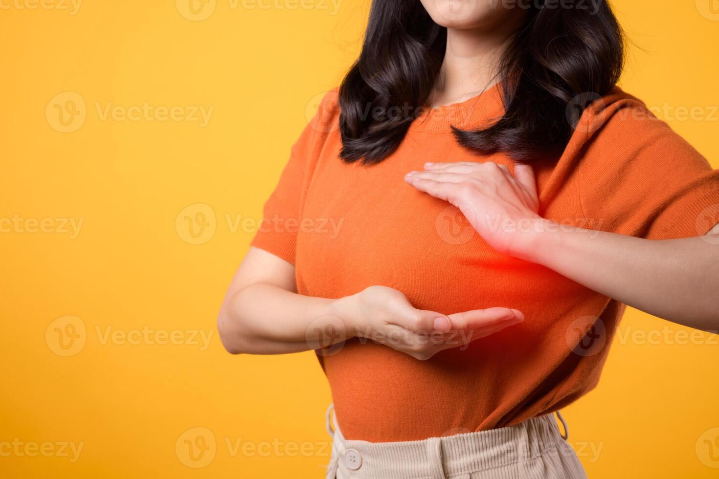 borst kanker Aan wereld Gezondheid dag, net zo een vrouw onderzoekt haar borst voor tekens Aan geel achtergrond. foto