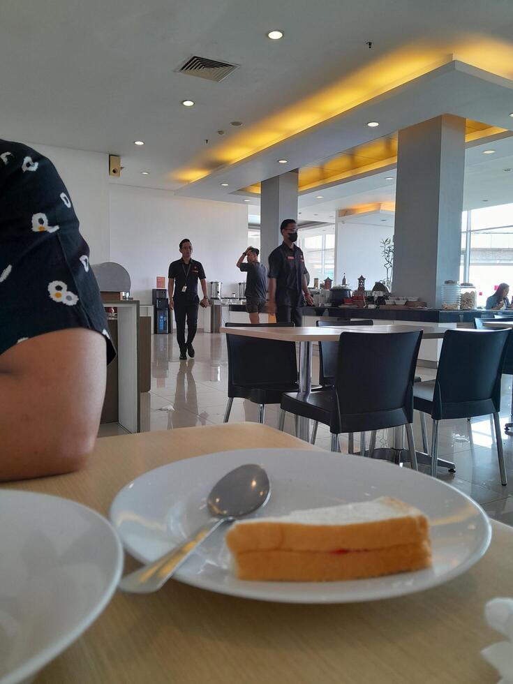 een Mens zittend Bij een tafel met een bord van voedsel foto