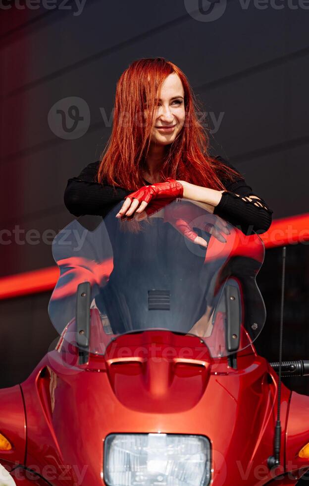 een vrouw zittend Aan een rood motorfiets. een vrouw zittend Aan top van een rood motorfiets foto