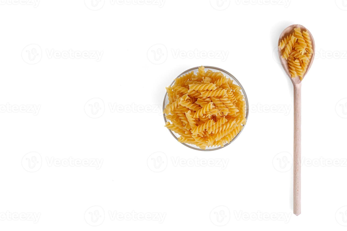 pasta in de het formulier van een spiraal Aan een bord, lepel, textuur, Aan een wit achtergrond foto