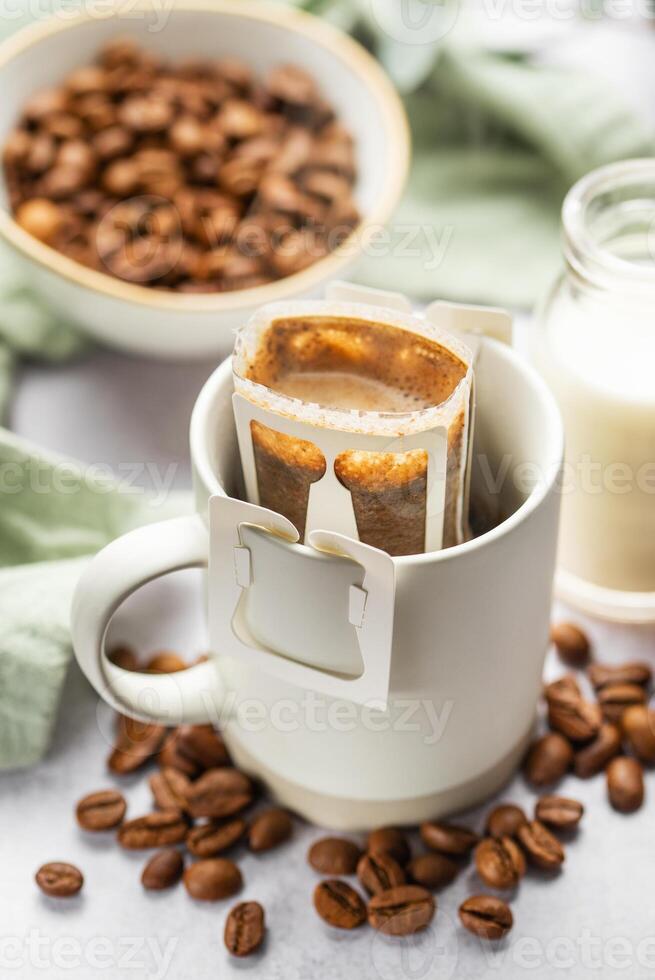 druppelen koffie zak met grond koffie in kop foto