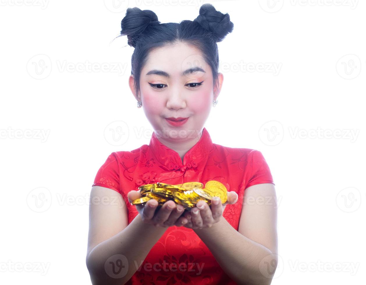 portret Aziatische jonge, vrouw rode jurk traditionele cheongsam met een gouden munt op de witte achtergrond foto