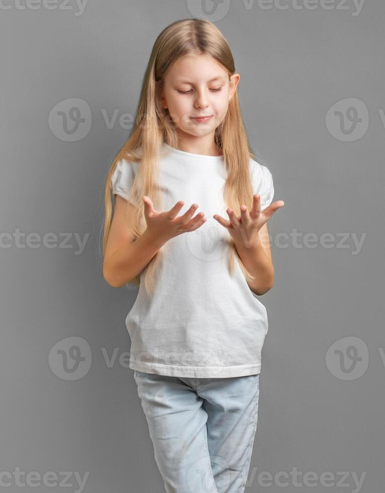 schattig weinig meisje op zoek Bij haar handen foto