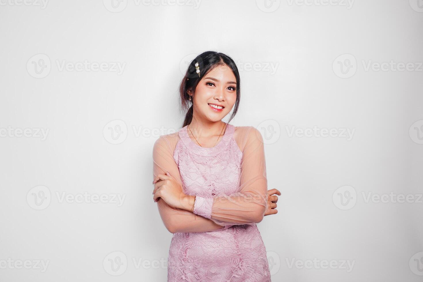 een aantrekkelijk Aziatisch vrouw vervelend roze jurk is glimlachen naar de camera, geïsoleerd door wit achtergrond. foto