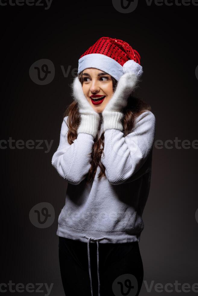 feestelijk vrouw met de kerstman hoed en handschoenen foto