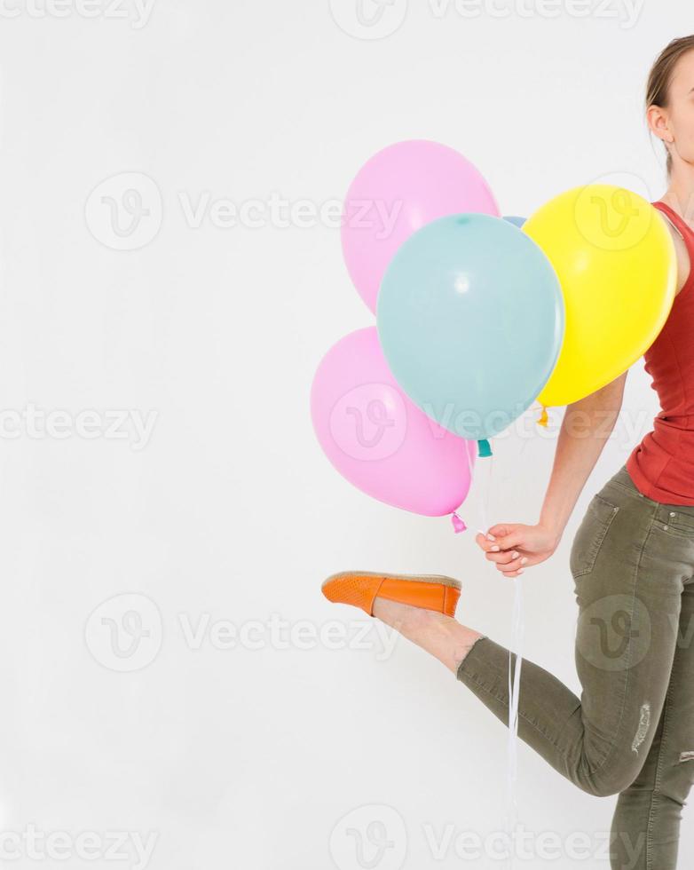 jonge vrouw meisje loopt met gekleurde ballonnen geïsoleerd op een witte achtergrond. kopieer ruimte foto