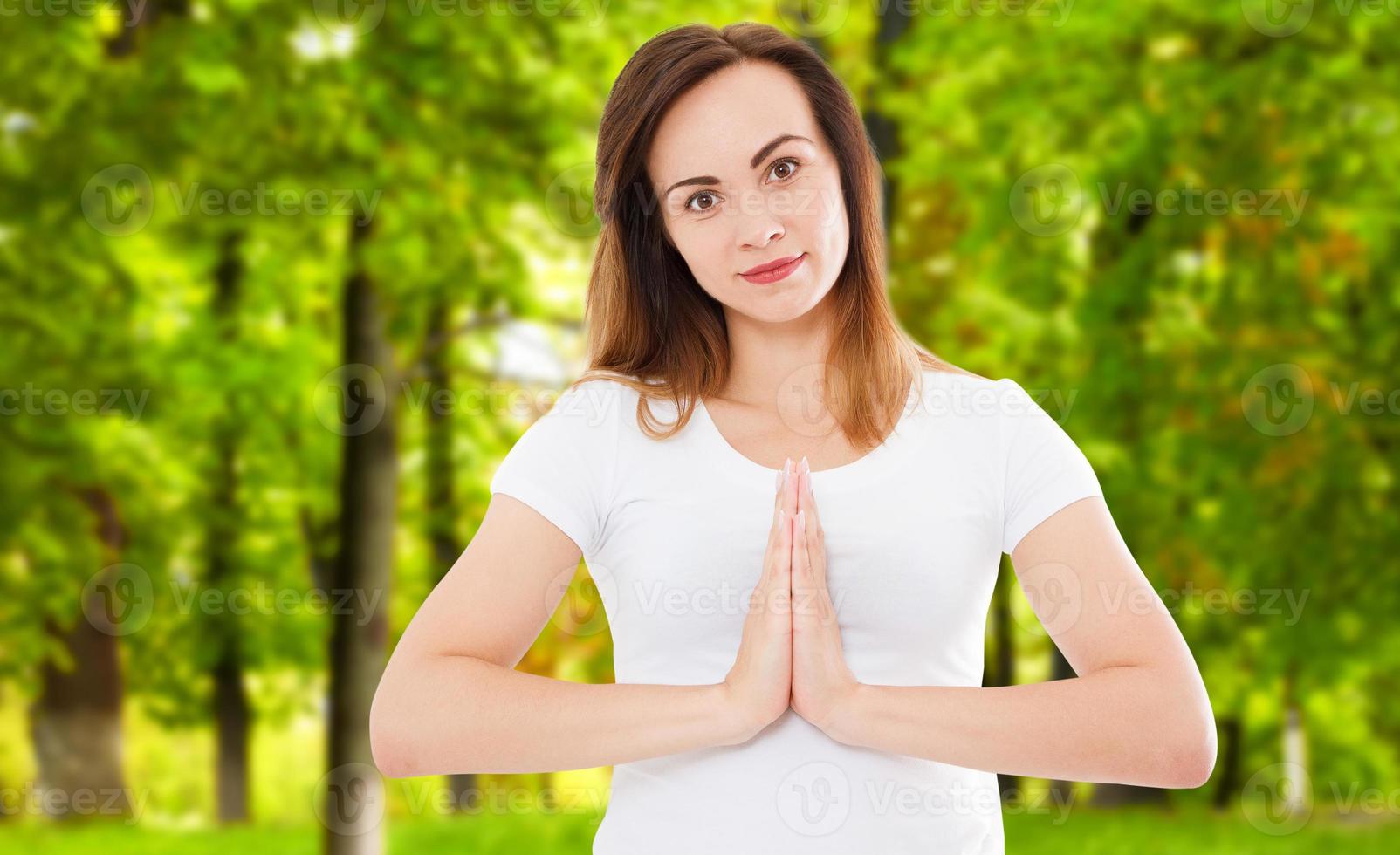 vrouw in namaste pose doet yoga in het park, namaste gebaar, helth concept foto