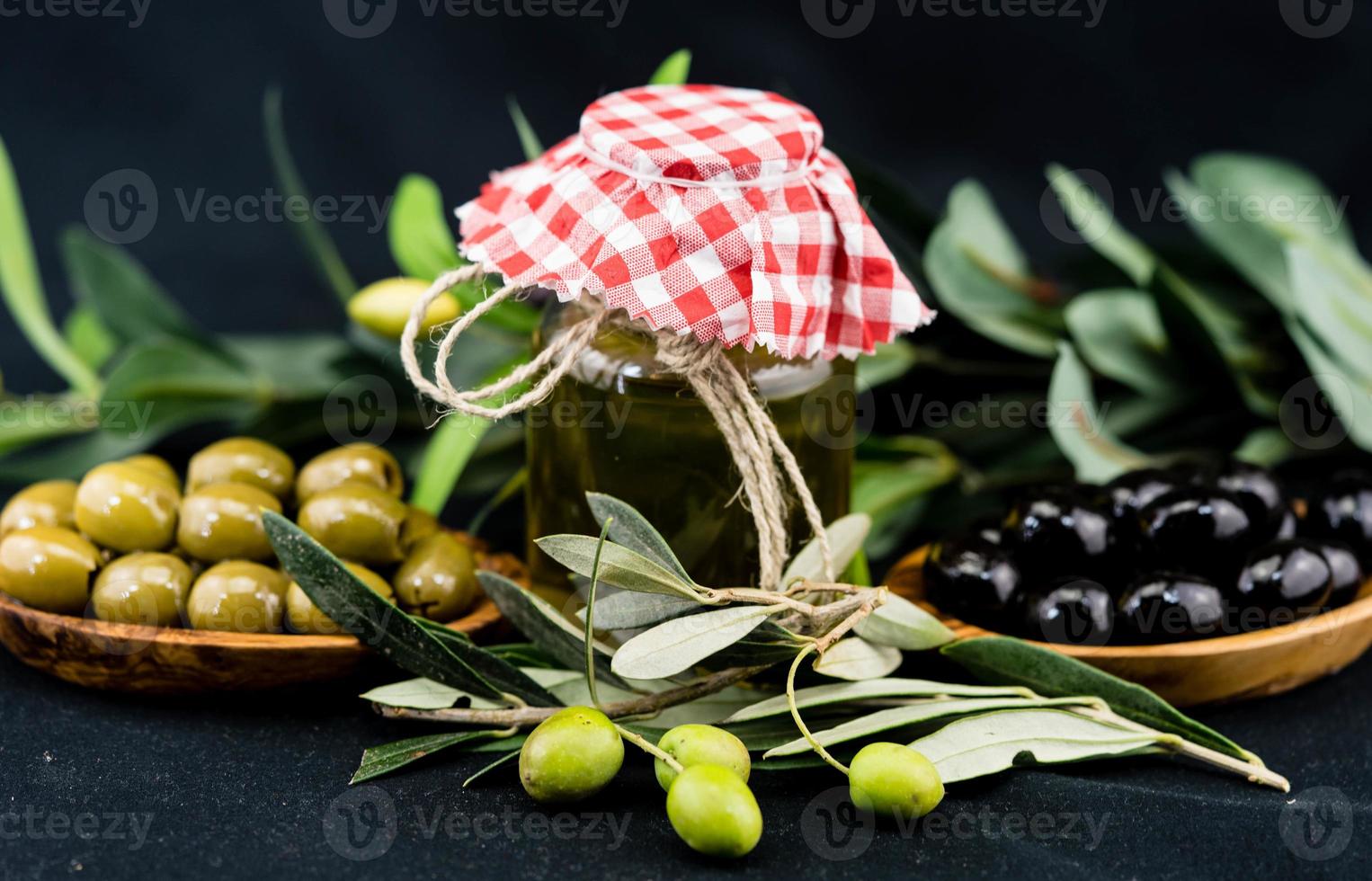 koudgeperste olijfolie met tak en fruit foto