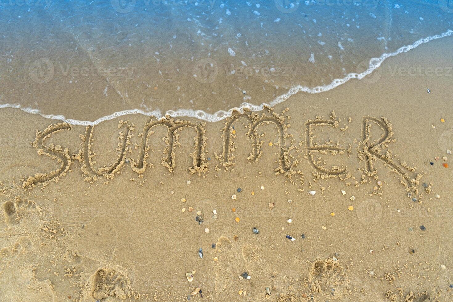 de woord zomer is geschreven Aan de geel zand van de strand. blauw Golf en surfen. toevlucht en vakantie. zomer Aan de kust. ontspanning rust uit concept foto