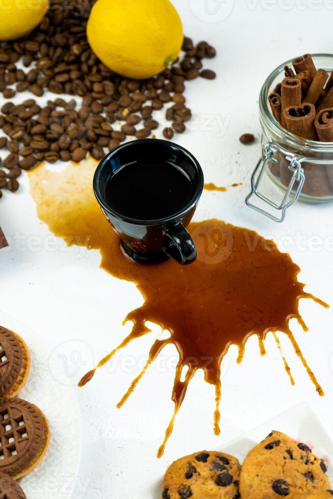 gemorst koffie van een zwart kop Aan een wit tafel. koffie bonen, kaneel en koekjes. ontbijt in de keuken foto