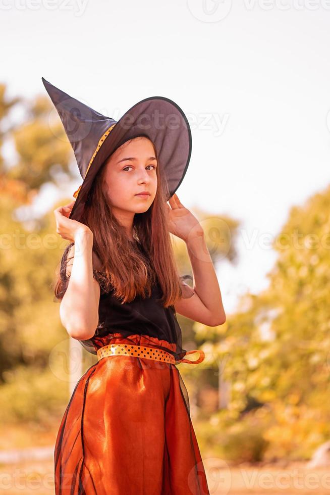 meisje van 11 jaar oud tegen de achtergrond van de herfstnatuur. klein meisje in halloween kostuum, herfst. foto