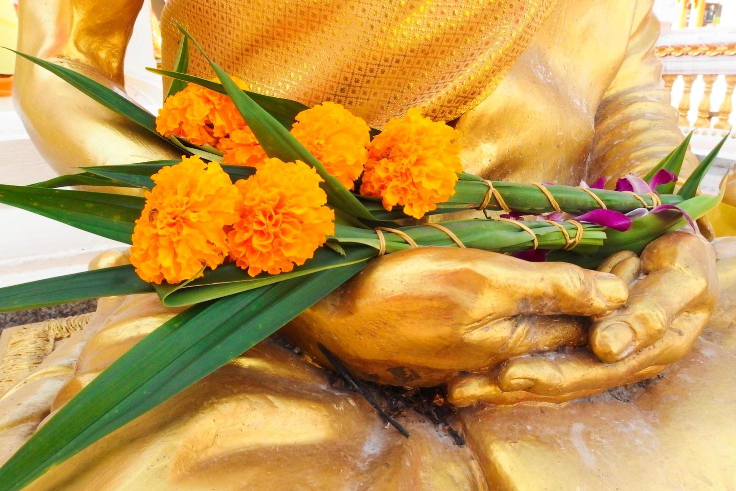 goudsbloemen worden op het boeddhabeeld geplaatst als een offerande tijdens het boeddhistische vesak-dagfeest. bloemen worden geassocieerd met religieuze ideeën of rituelen. foto