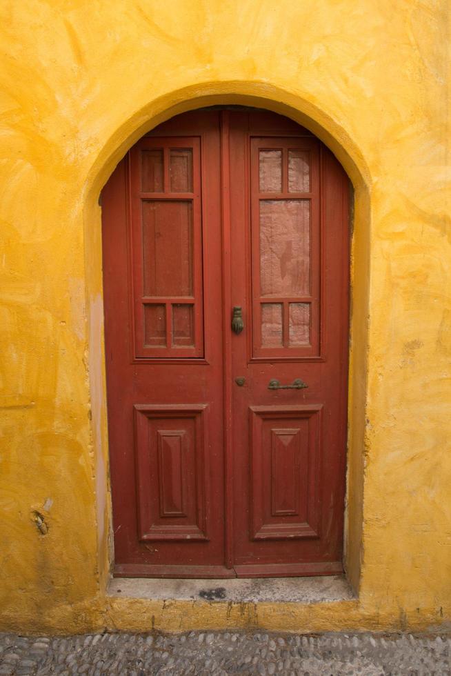 kleurrijke muren en houten deur in de oude stad van rhodos, griekenland foto