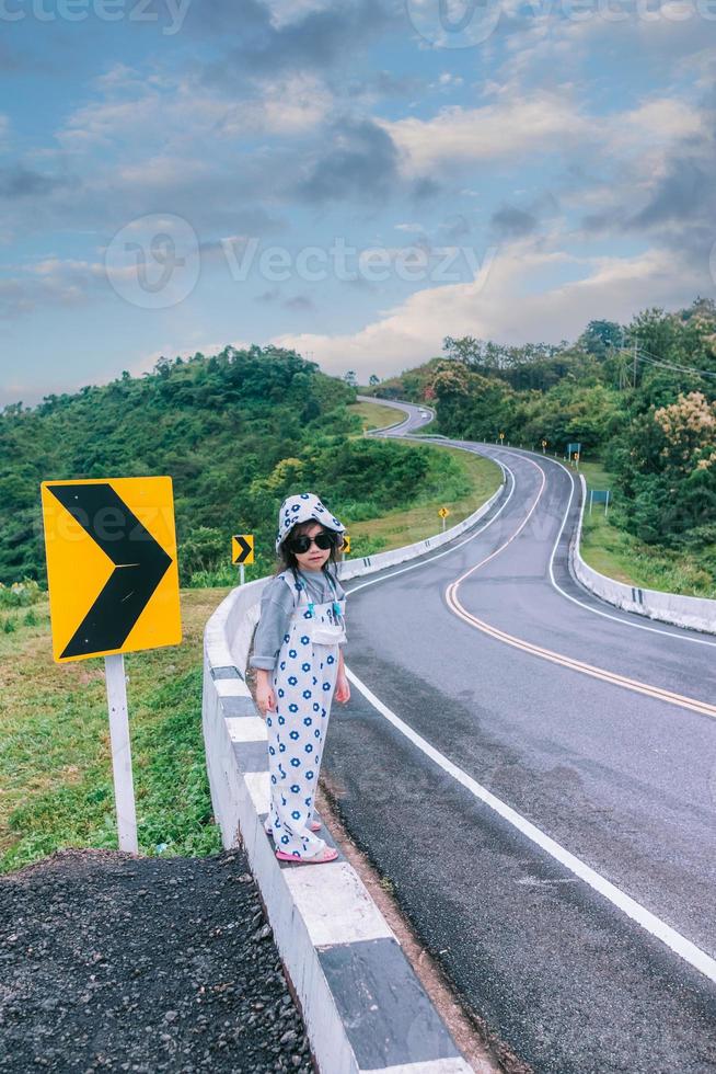 klein meisje dat langs de weg loopt foto