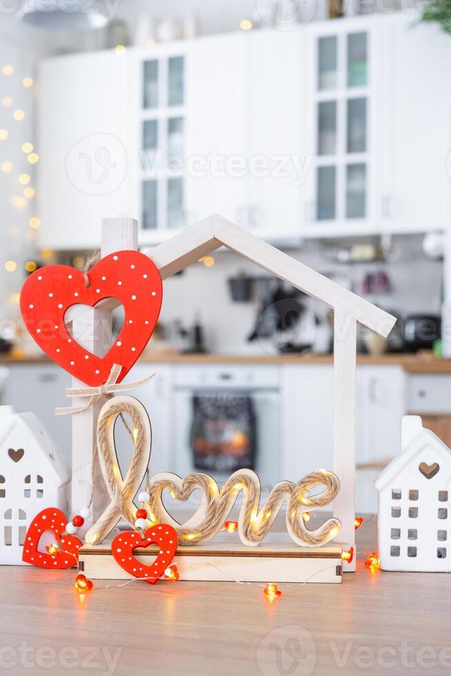 sleutel naar klein huis van knus huis met Valentijn decor Aan tafel van keuken. geschenk voor valentijnsdag dag, familie liefde nest. ontwerp, projecteren, in beweging naar nieuw huis, hypotheek, huur en aankoop echt landgoed foto