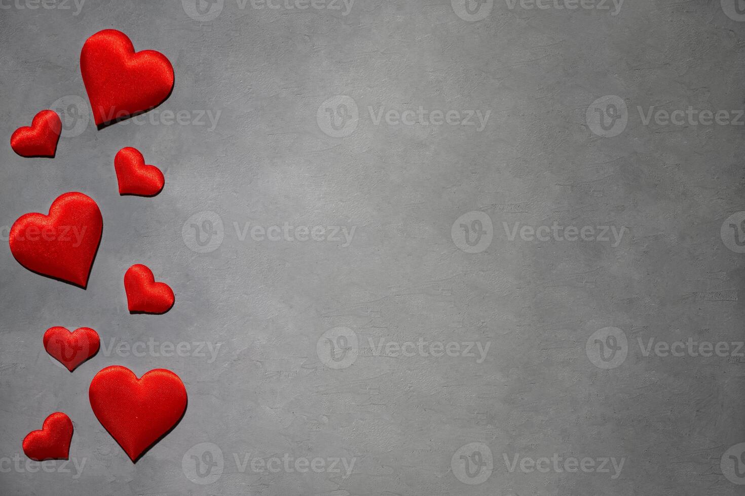 rood harten Aan een grijs achtergrond. achtergrond voor een ansichtkaart foto