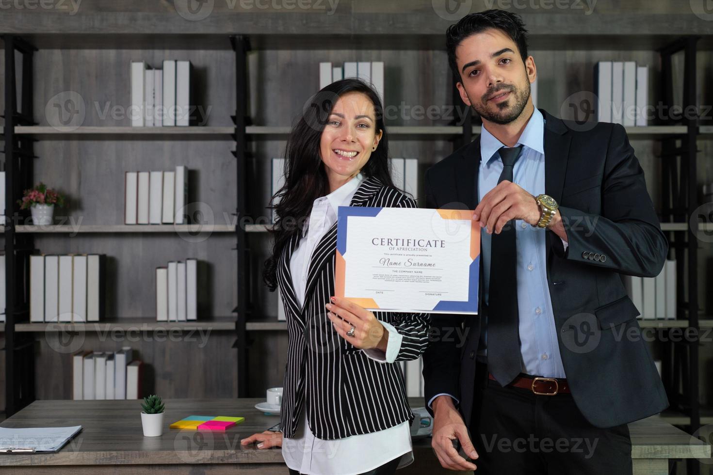 jonge blanke zakenvrouw en Arabische zakenman krijgen certificaat van nieuw projectontwerp en tonen het op kantoor foto