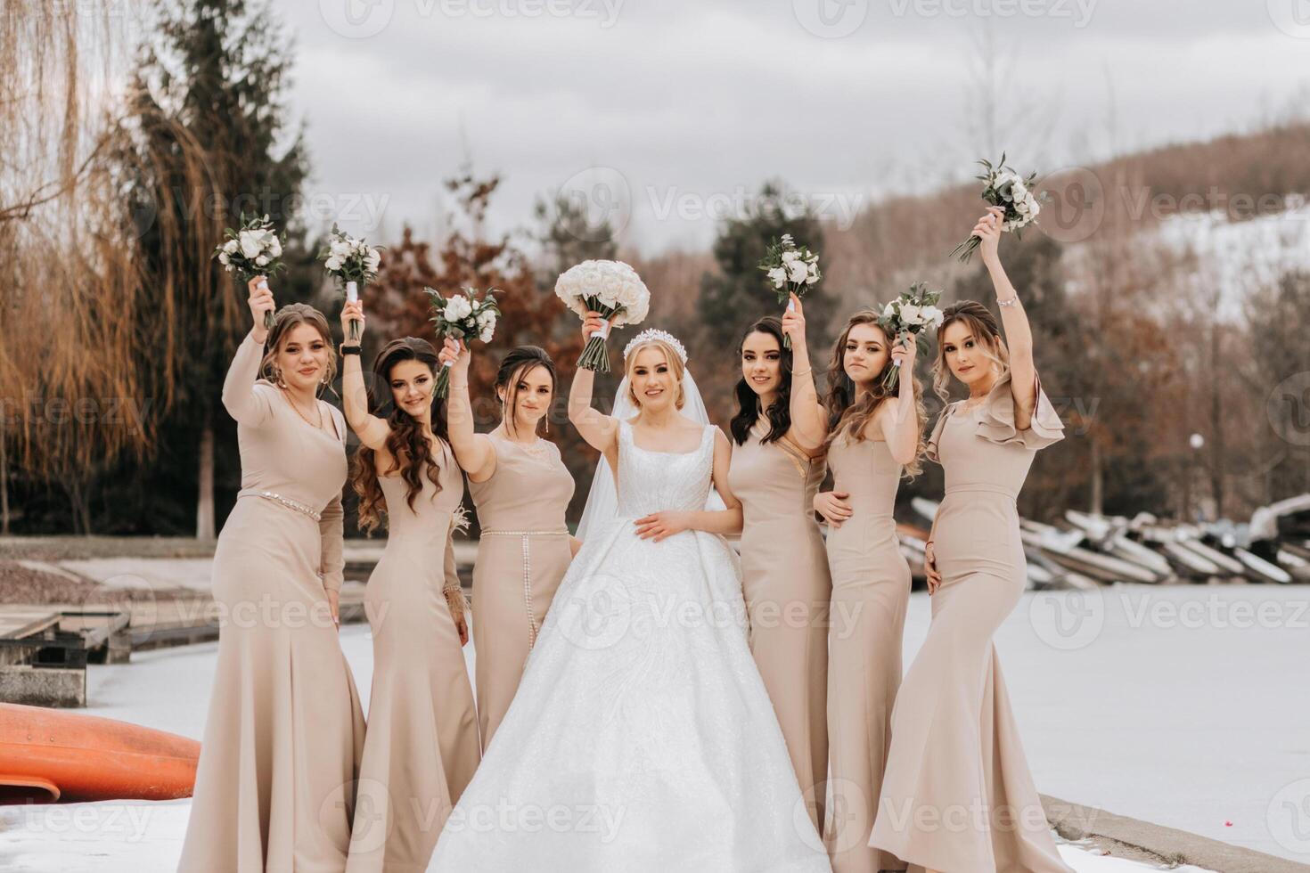 de bruid en haar bruidsmeisjes houding Holding boeketten en op zoek Bij de bruid. winter bruiloft foto
