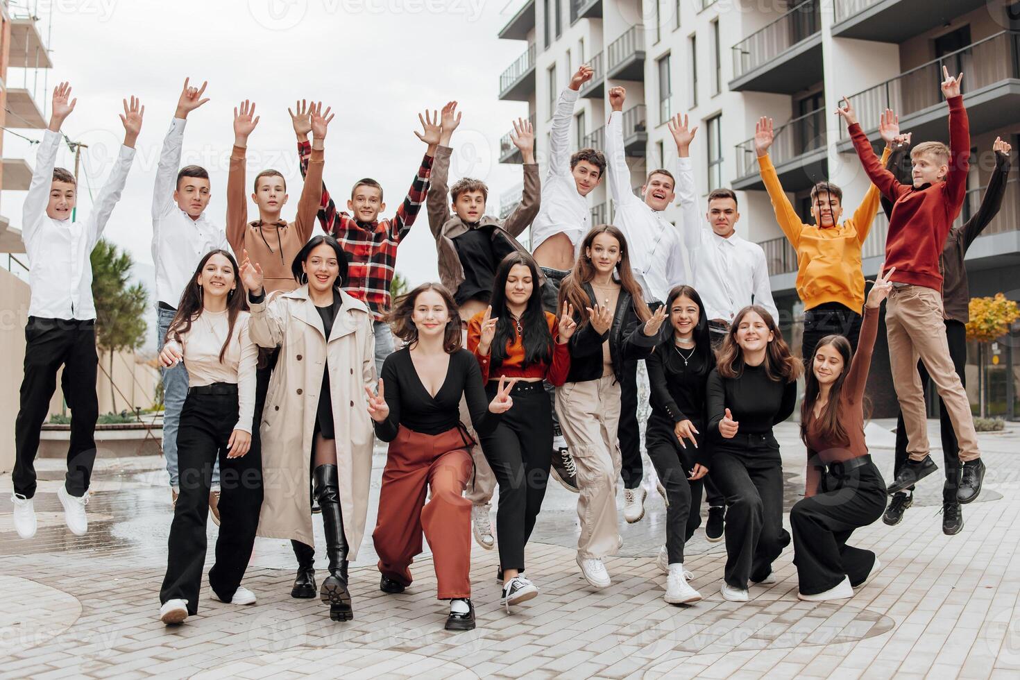 vriendschap, beweging, actie, vrijheid en mensen concept - groep van gelukkig tieners of school- vrienden poseren en hebben pret buitenshuis Aan achtergrond van mooi plaats of middelbare school. foto