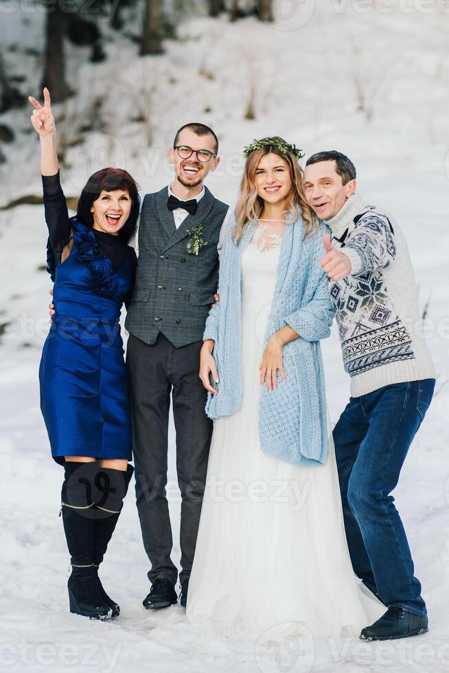 bruiloften, paren en familie vieren huwelijk voor inzet, vertrouwen of verhouding steun. portret van getrouwd bruid en bruidegom met gelukkig ouders. bruiloft in winter foto