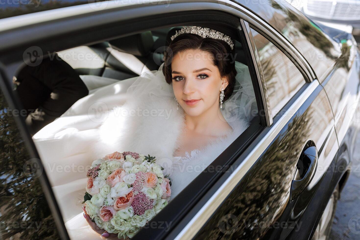 portret van een ongelooflijk mooi bruid in de venster van een duur auto. de bruid met een boeket van bloemen looks in de camera lens. foto