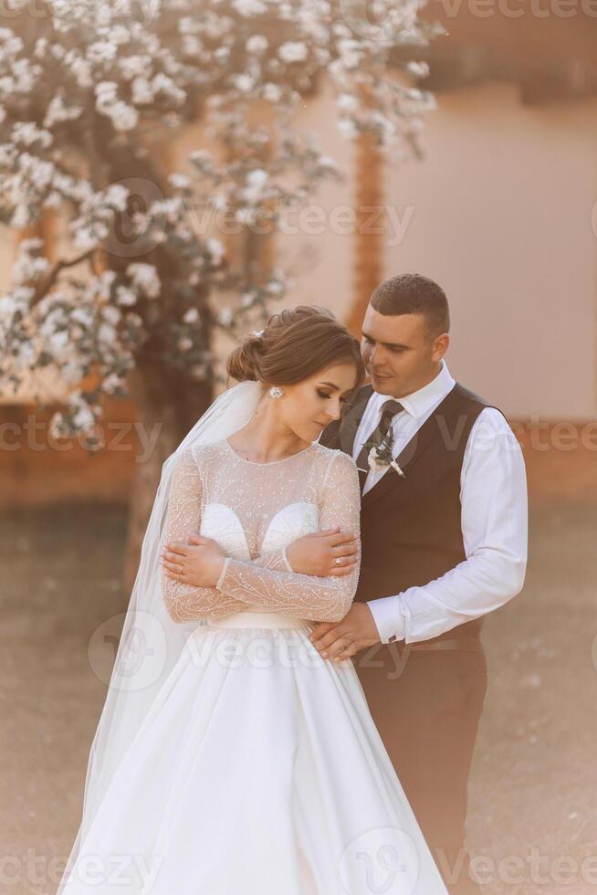 bruiloft. liefde en paar in tuin voor bruiloft. viering van ceremonie en inzet. opslaan de datum. vertrouwen. de bruid en bruidegom omarmen. glimlach en liefde in de park. de bruidegom omarmt de bruid. foto