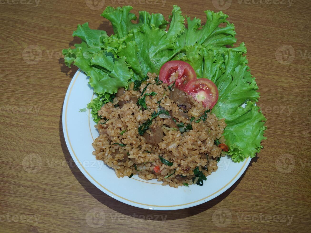 heerlijk Indonesisch gebakken rijst- nasi goreng met veel van sla, mosterd Groenen en tomaten geserveerd Aan een wit bord foto