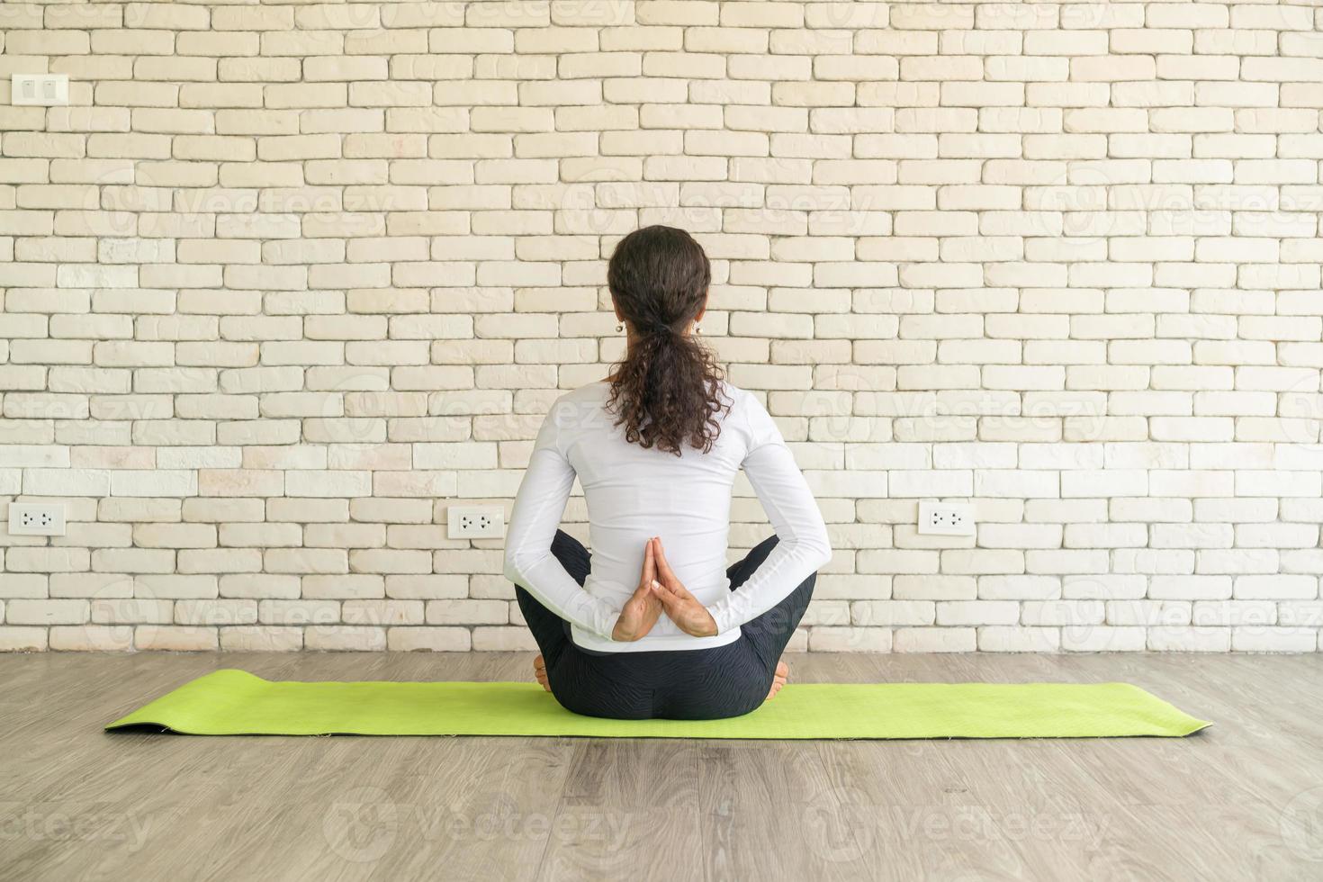 latijnse vrouw die yoga beoefent op mat foto