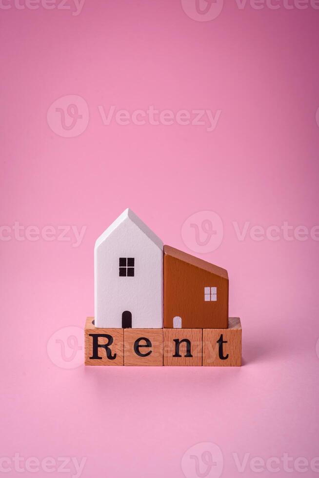 klein houten huis en de opschrift voor huur. concept voor uitverkoop, verhuur van echt landgoed voor een familie foto