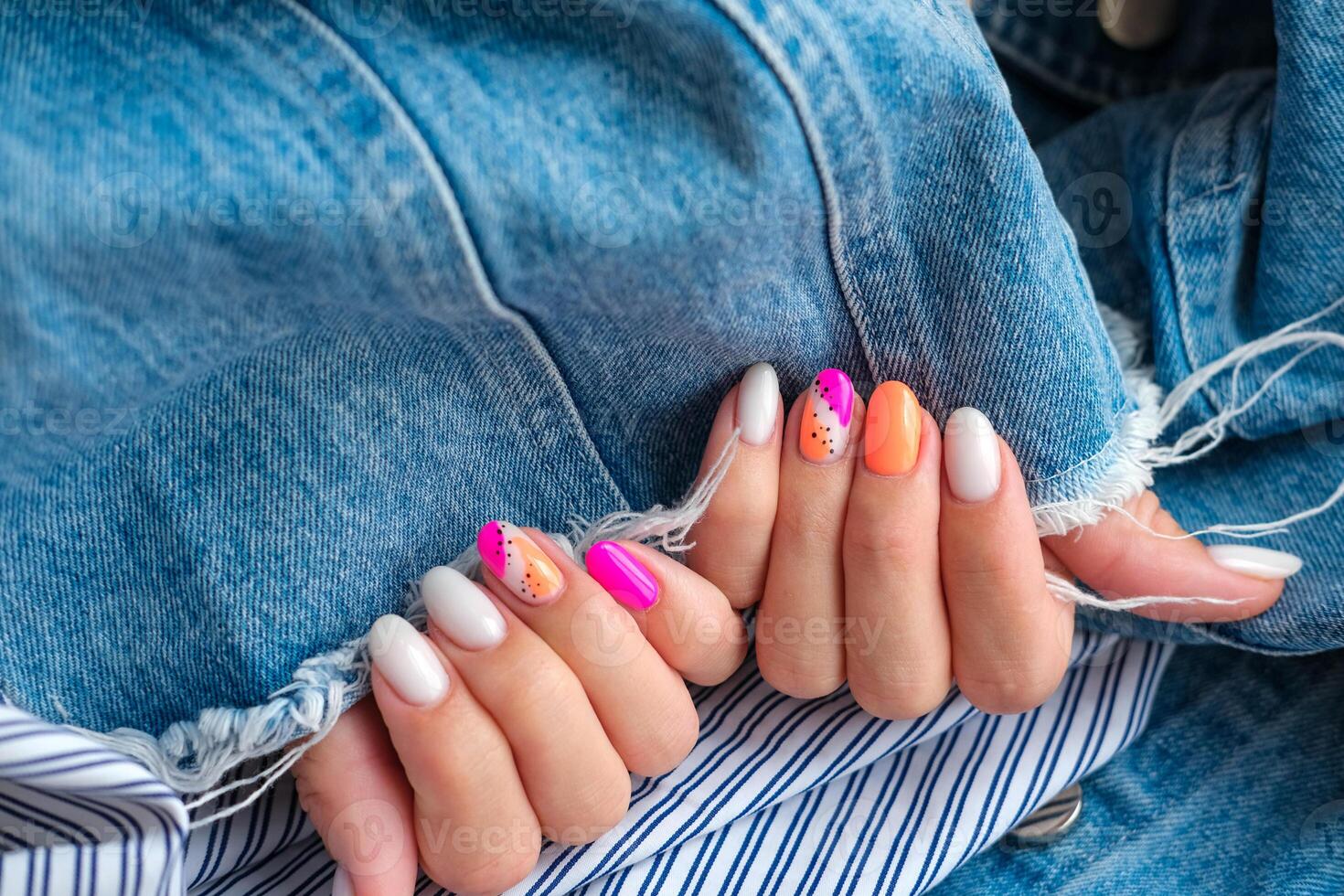 mooi vrouw handen met manicure Aan een denim achtergrond. elegant nagel ontwerp. zomer manicure met oranje-roze patroon Aan de nagels. kopiëren ruimte. foto