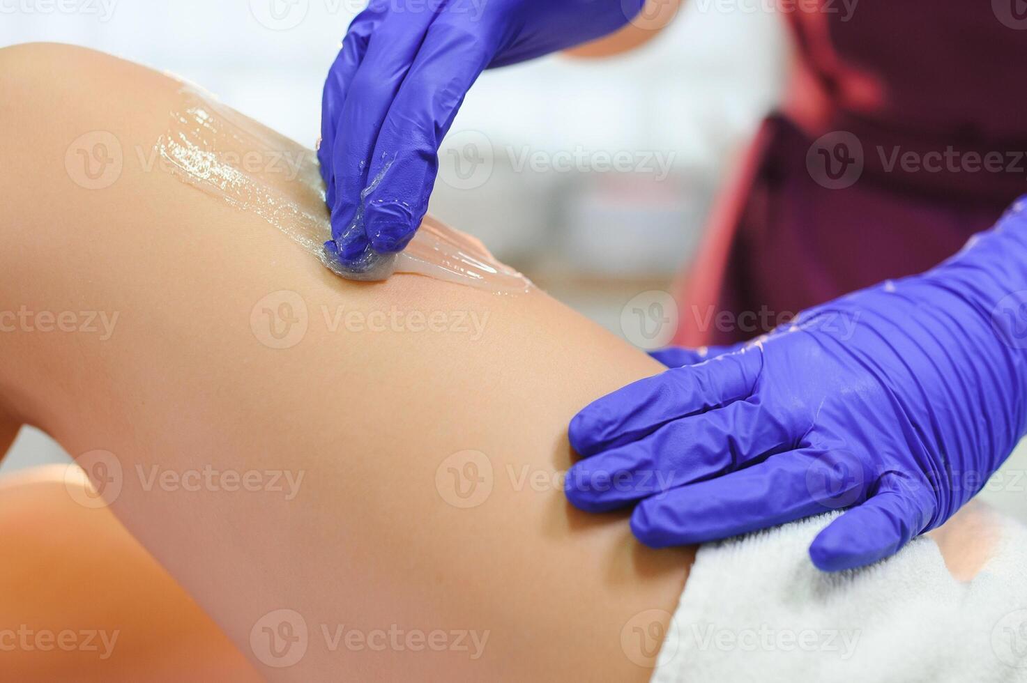 vrouw hebben haar- verwijdering procedure Aan been met suikerhoudend Plakken in salon foto