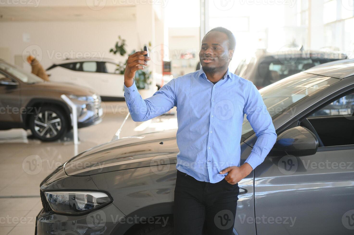 gelukkig glimlachen Mens Holding auto sleutels aanbieden nieuw auto Aan achtergrond foto