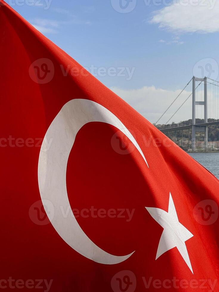 Turks vlag fladderend in de wind met Istanbul en de gouden toeter brug in de achtergrond, kalkoen foto