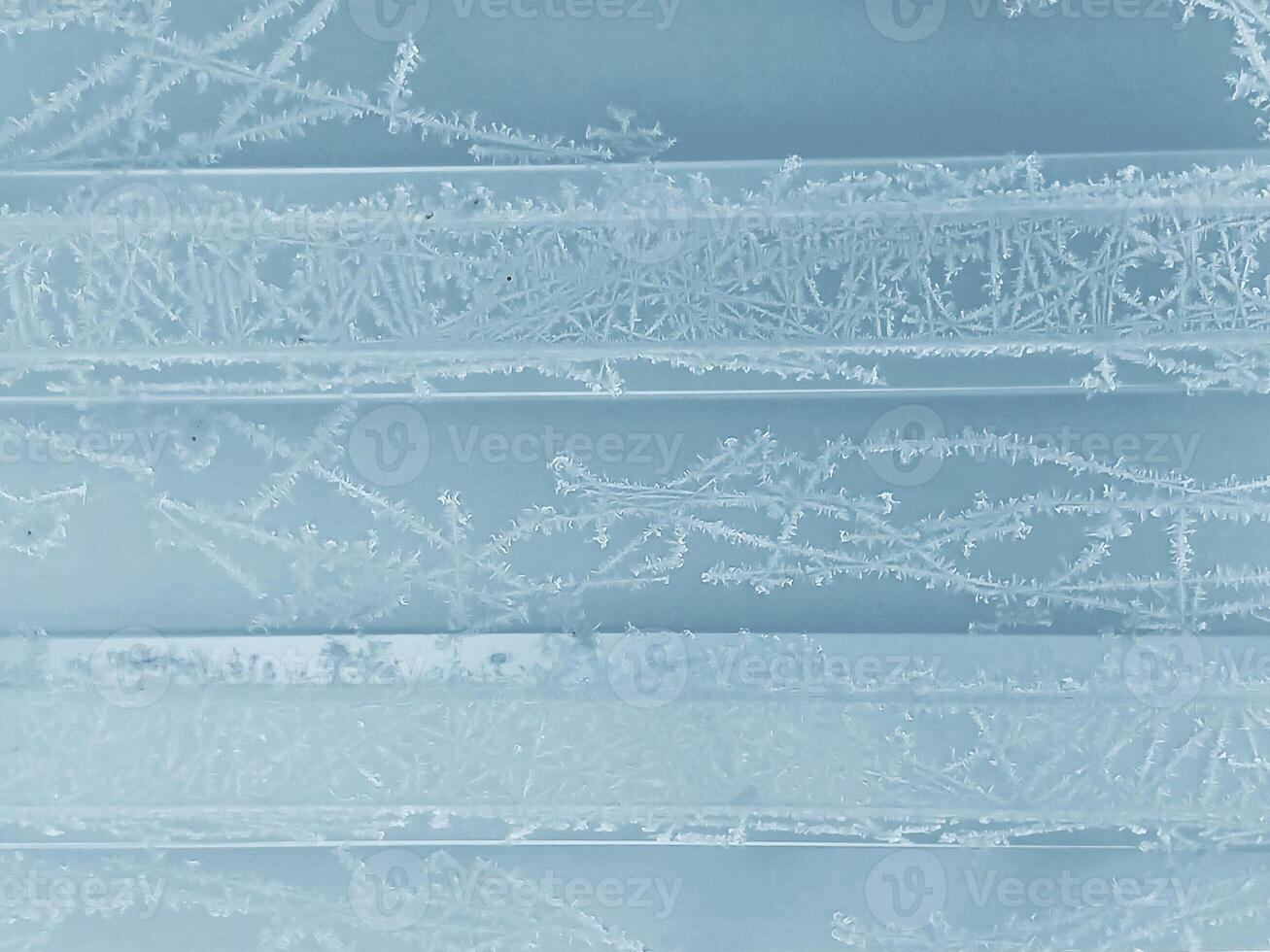 winter ijzig achtergrond met sneeuw patronen en vorst Aan een blauw structuur foto