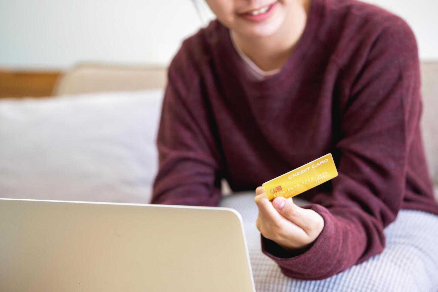 mooi Aziatisch Dames gebruik makend van credit kaarten voor boodschappen doen online met laptops en smartphones, online boodschappen doen portret concept. foto