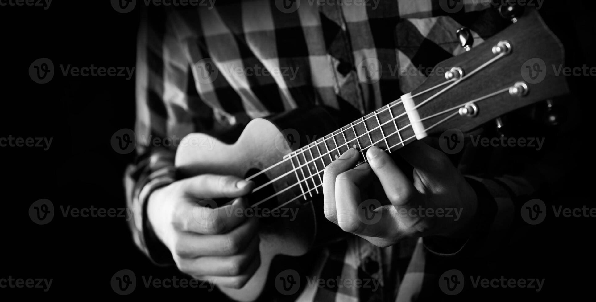 een jong Mens spelen ukulele in dichtbij omhoog visie foto