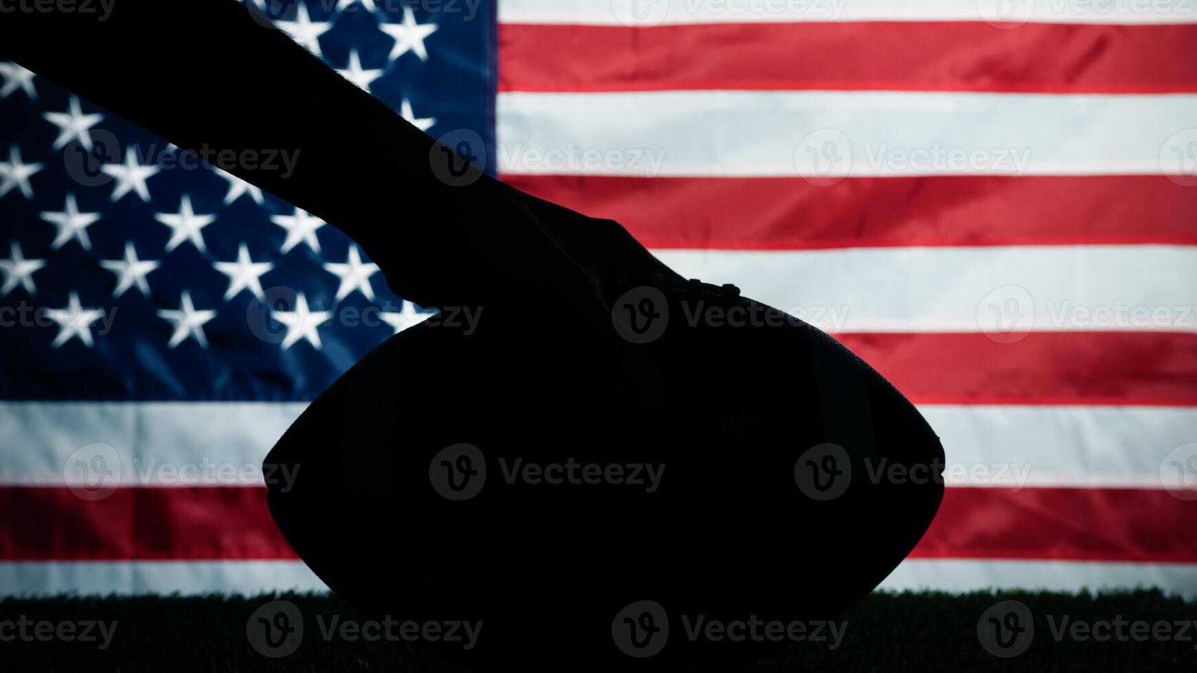 hand- Holding silhouet van Amerikaans Amerikaans voetbal bal tegen Verenigde Staten van Amerika vlag foto