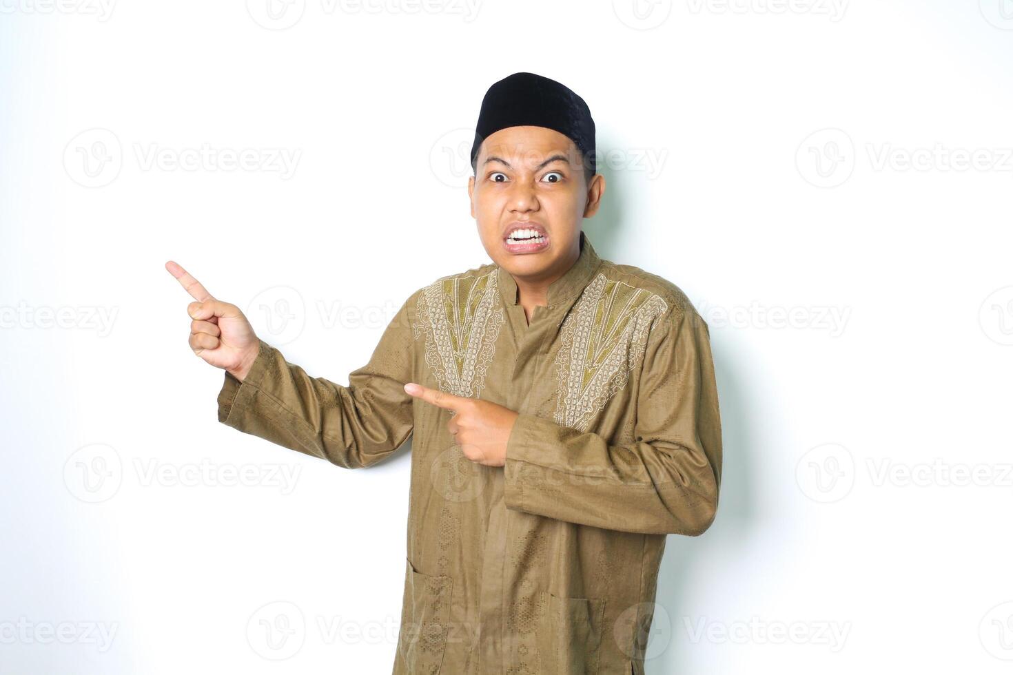 boos Aziatisch moslim Mens vervelend Arabisch kostuum richten naar kant en kijken Bij camera geïsoleerd Aan wit achtergrond foto