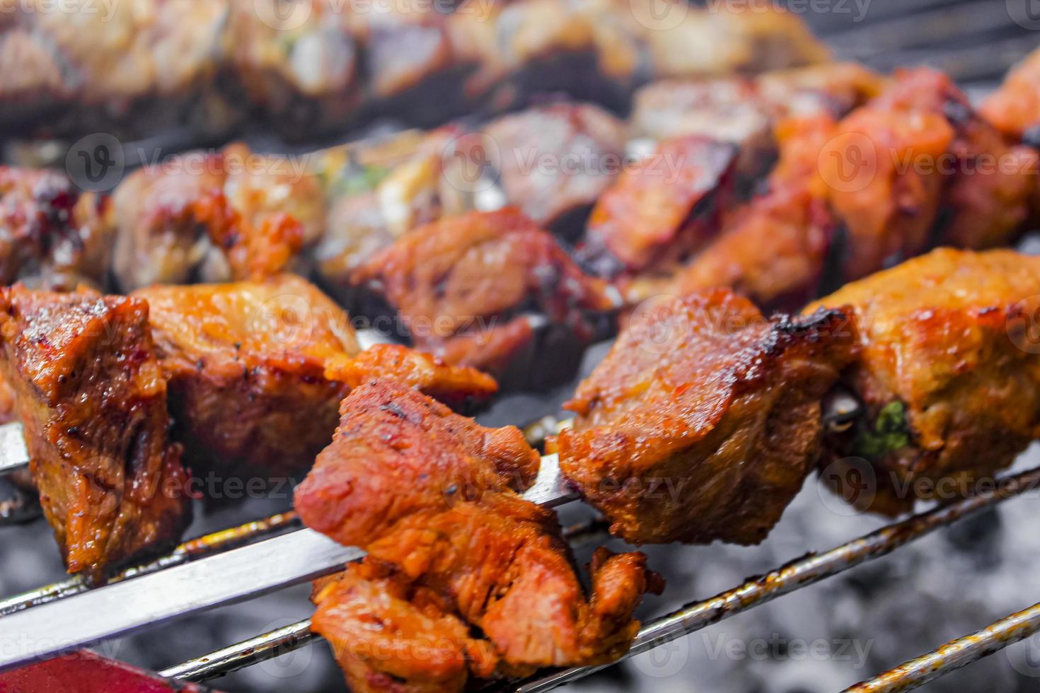 Russische sjasliek met spiesjes op een ronde grill. foto