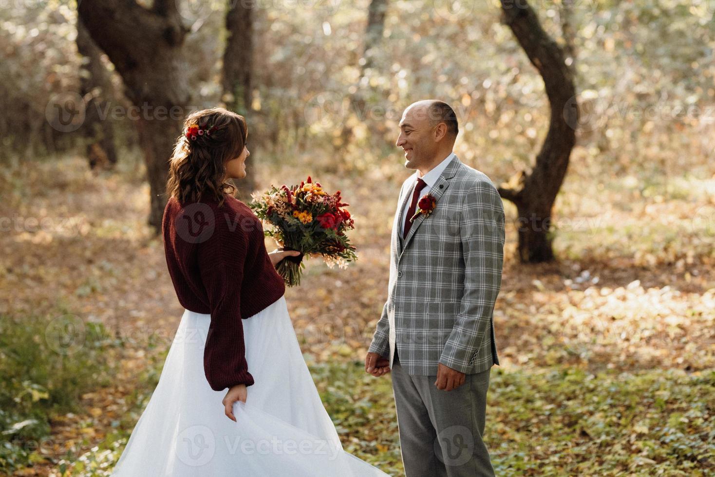 wandeling van de bruid en bruidegom door het herfstbos foto