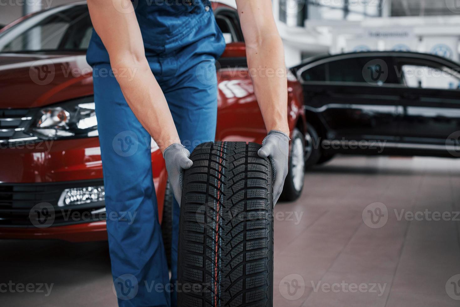 een monteur met een bandenbus in een reparatiegarage. vervanging van winter- en zomerbanden foto