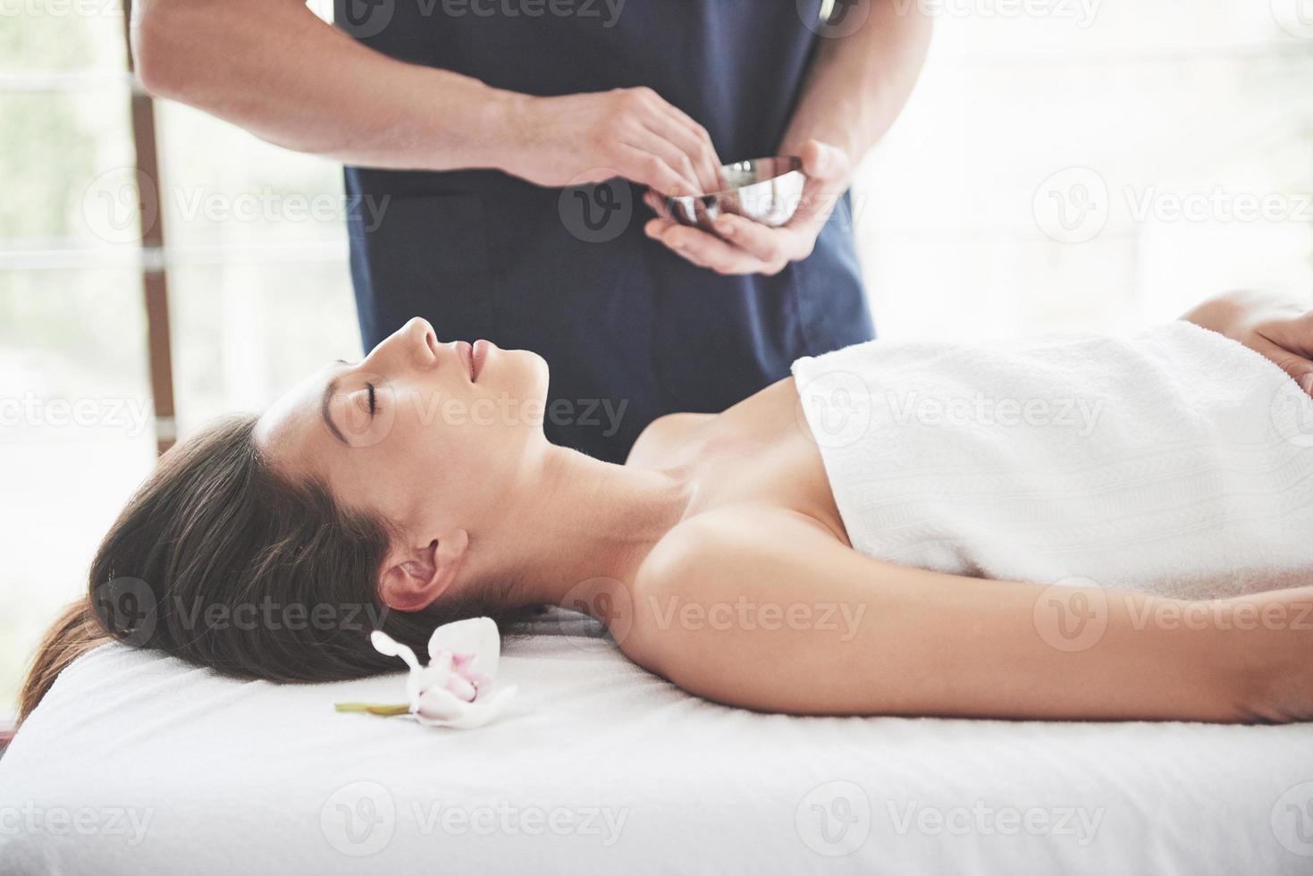 mooie vrouw liggend op een massagetafel in de spa. foto