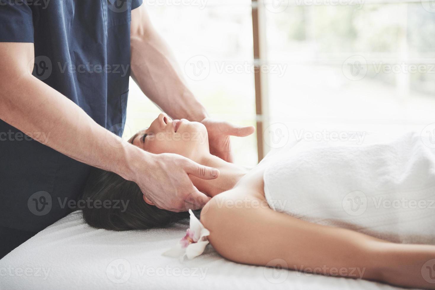 masseur maakt ontspanningsmassage voor een nek voor een vrouw. foto