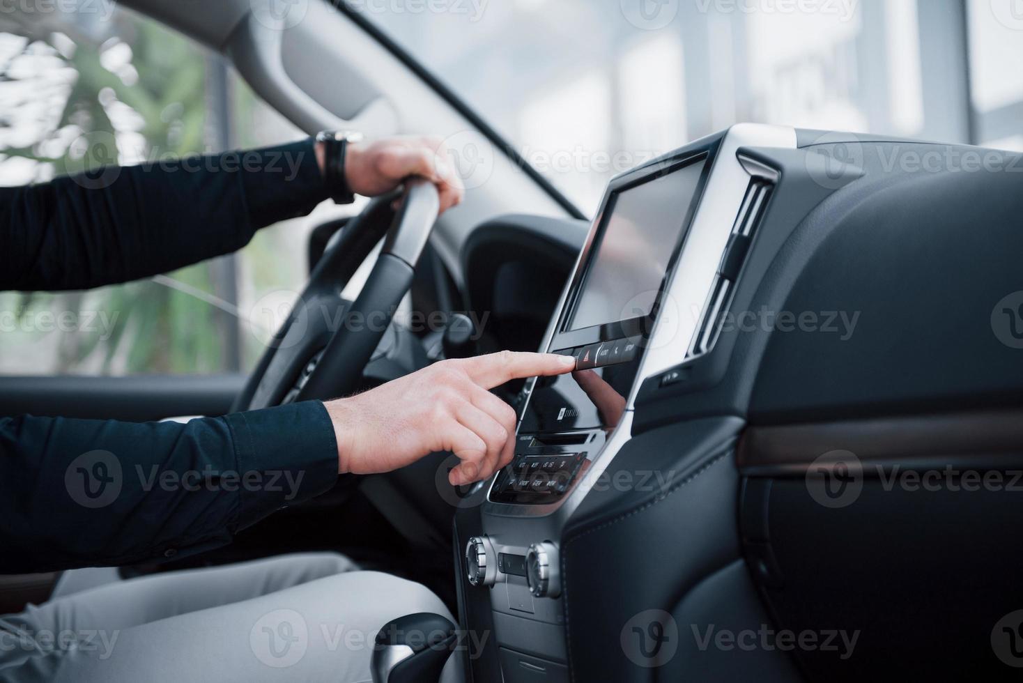 close-up van een jonge man die een auto bestuurt. een zakenreis beginnen. proefrit een nieuwe auto foto