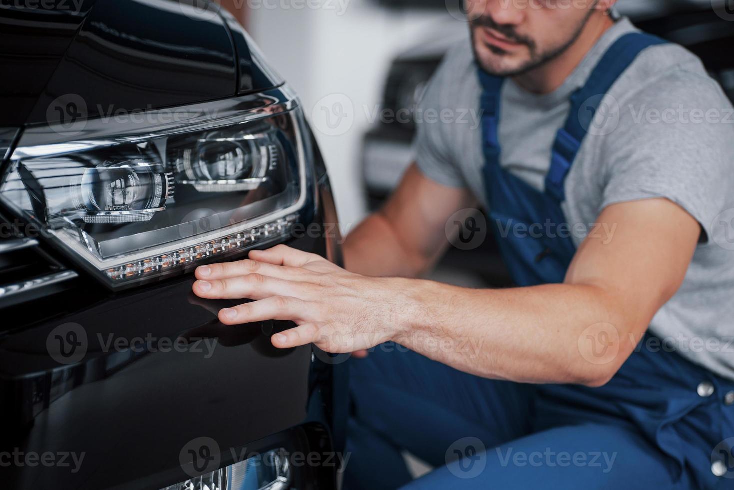 portret van een gelukkig lachende man die een nieuwe auto in de cabine kiest. foto